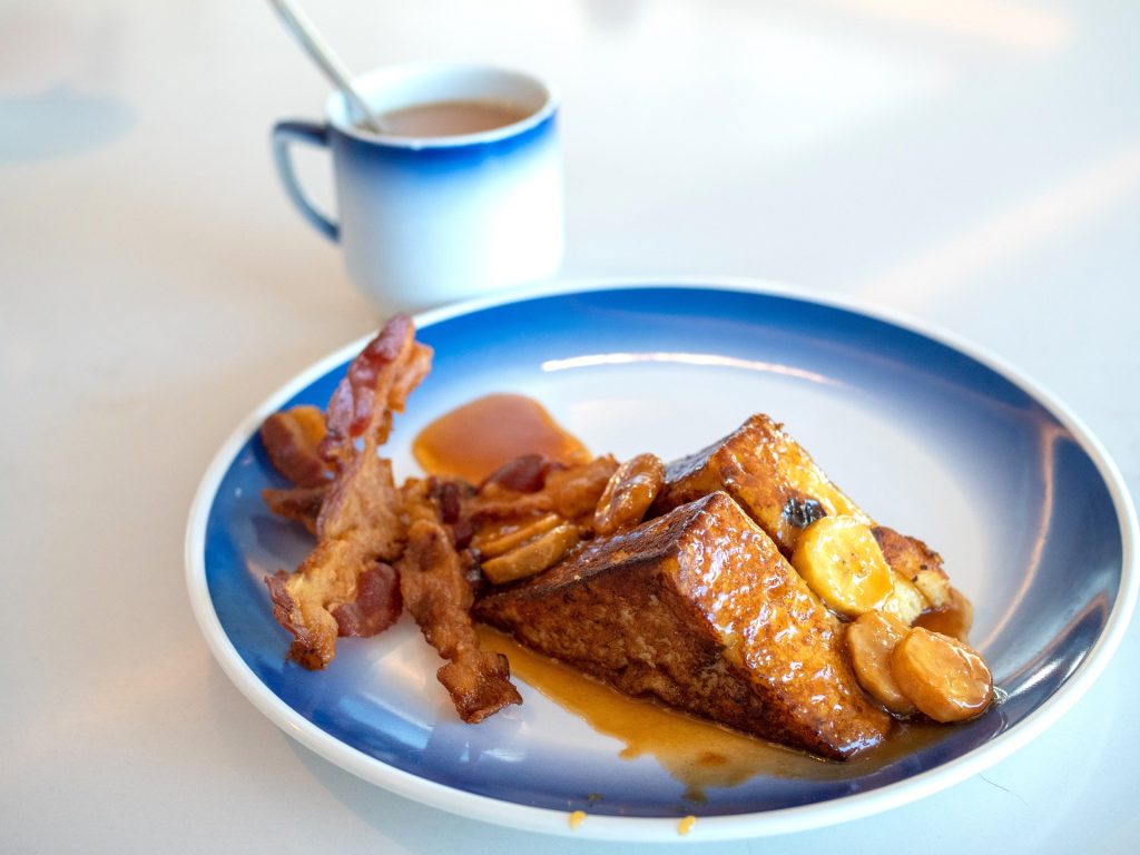French toast covered in syrup with a side of bacon and coffee in Victorville, CA